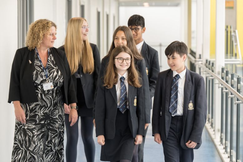 Sally Bishop walking with students walking on corridor