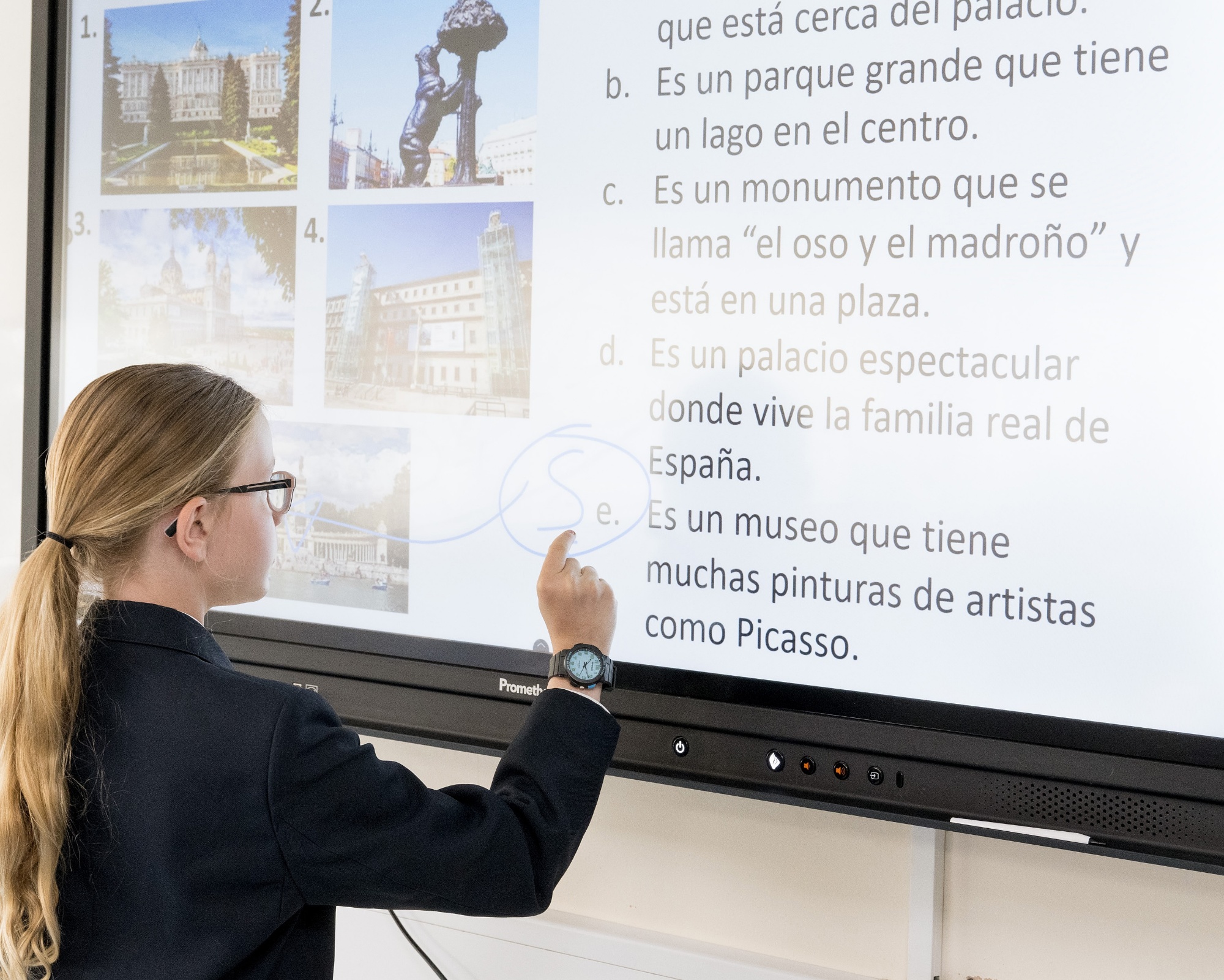 teacher and student working in Spanish on a smartboard